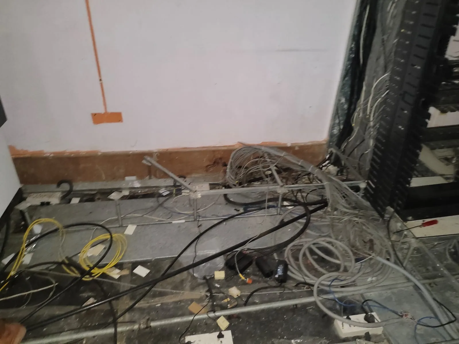 Systematic removal of data cables and backup systems indicating IT office decommissioning OMR actions.